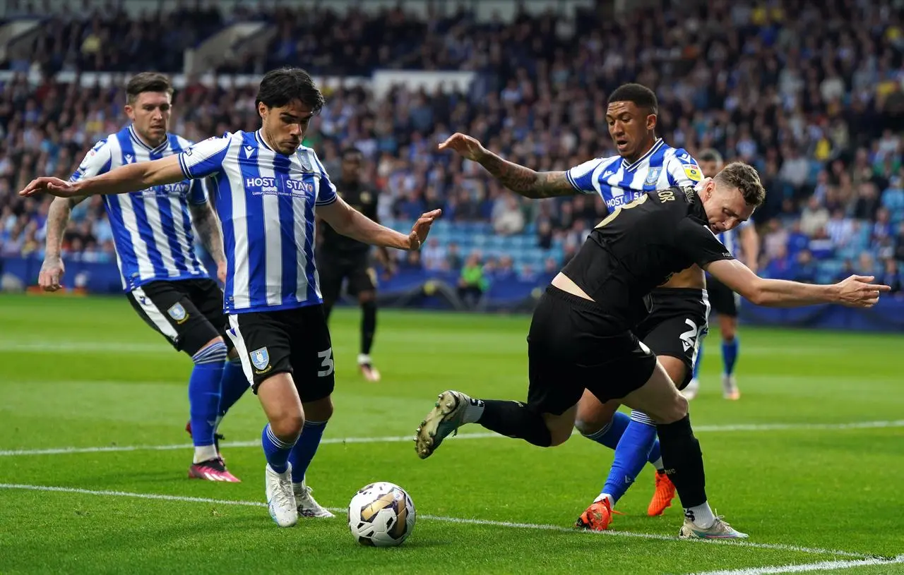 Sheffield Wednesday’s Reece James (left) and Liam Palmer battle for the ball with Peterborough United’s Jack Taylor