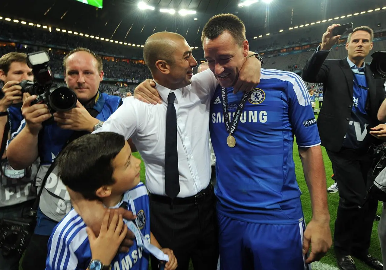 Suspended Chelsea captain John Terry, pictured interim manager Roberto Di Matteo, donned full kit to join in the celebrations