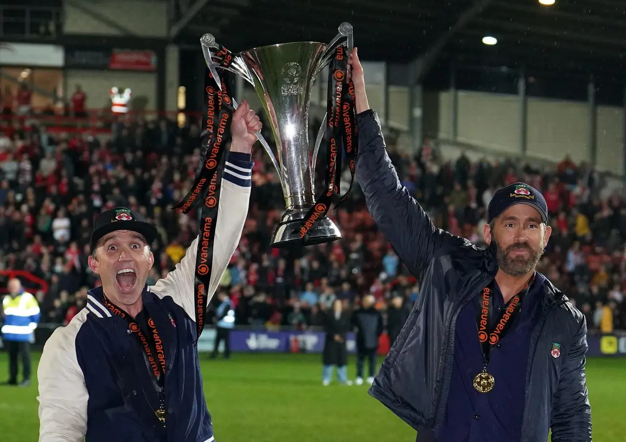 Rob McElhenney (left) and Ryan Reynolds celebrate with the National League trophy after Wrexham secured promotion last month 