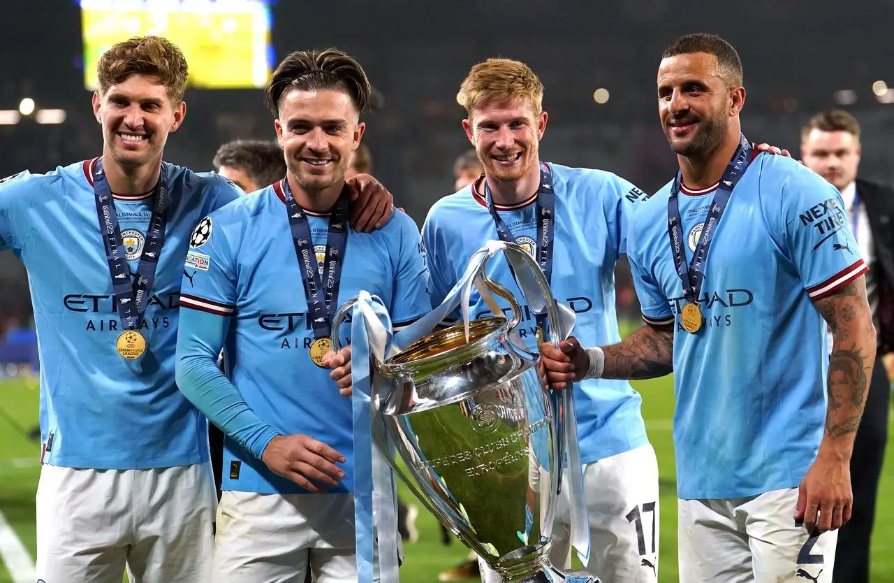 Kyle Walker, right, with John Stones, left, Jack Grealish and Kevin De Bruyne after winning the Champions League 