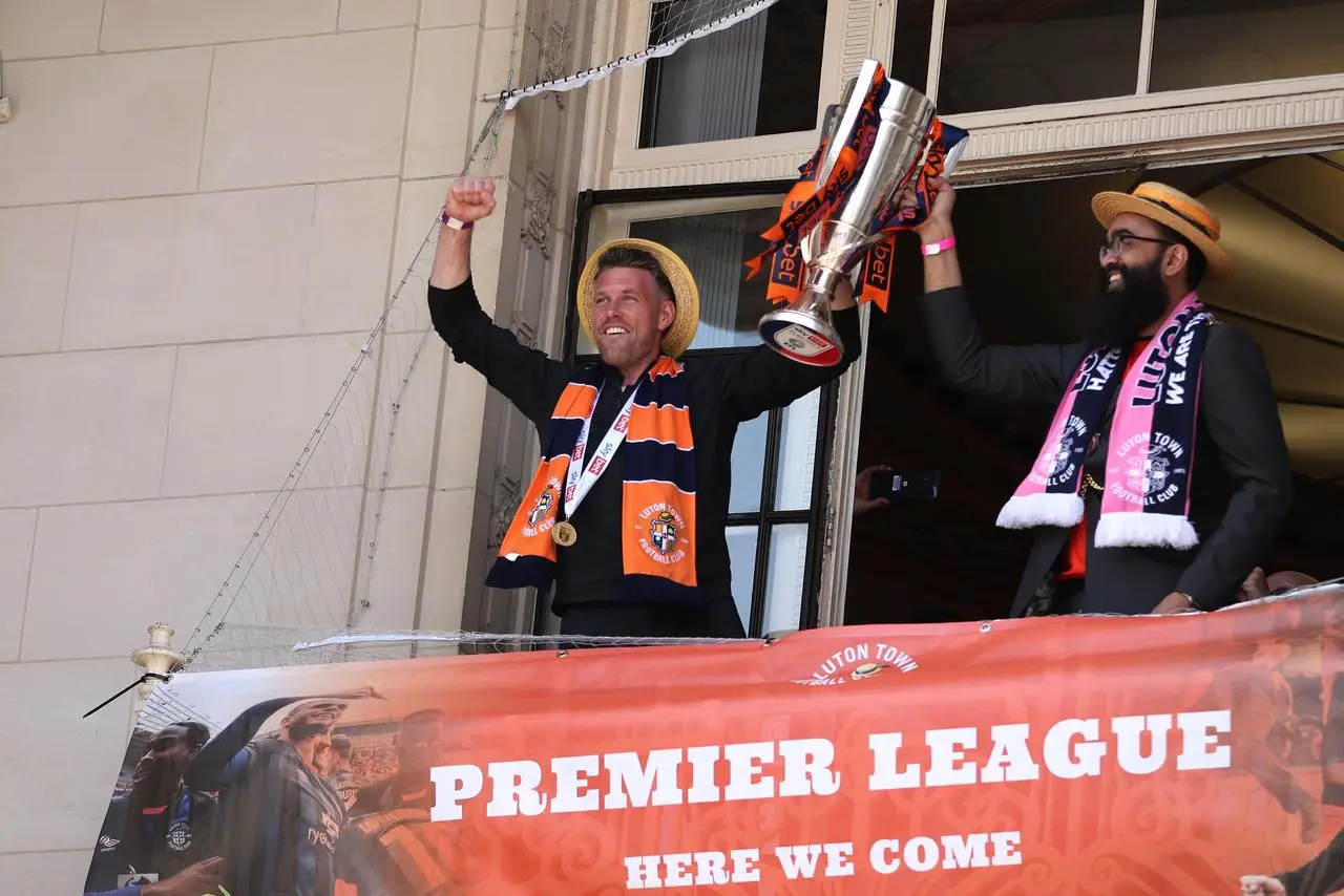 Luton manager Rob Edwards, left, holds up the Championship play-off trophy during a promotion celebration in the city centre