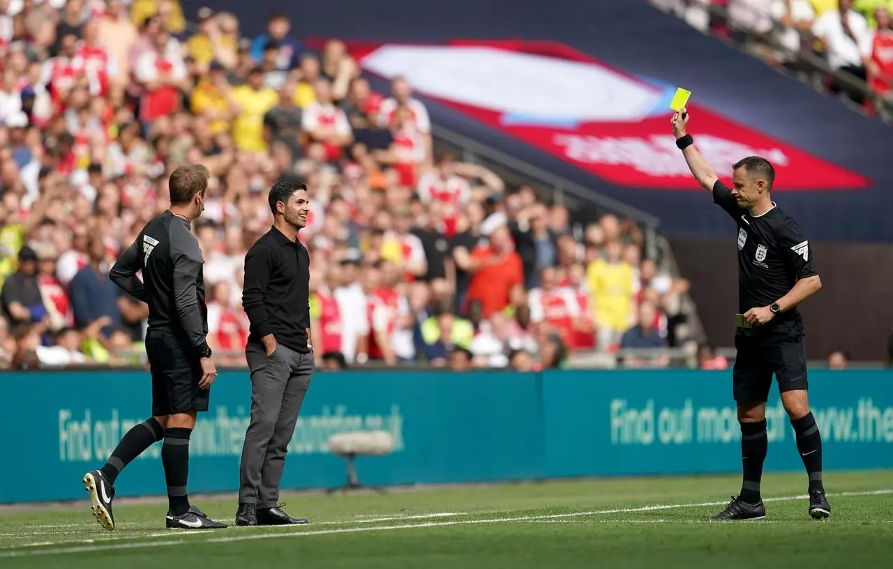 Mikel Arteta is shown a yellow card by Stuart Attwell 