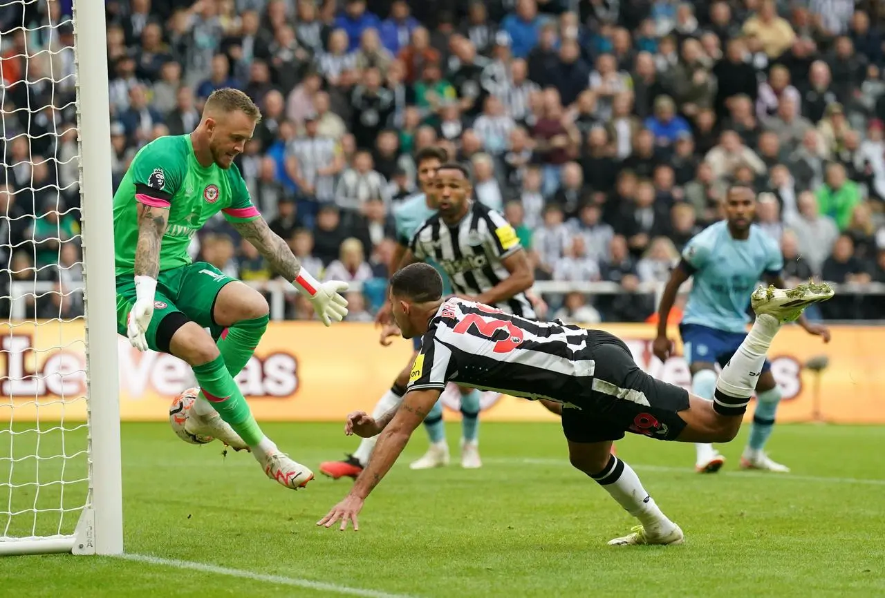 Mark Flekken, left, saves from Bruno Guimaraes