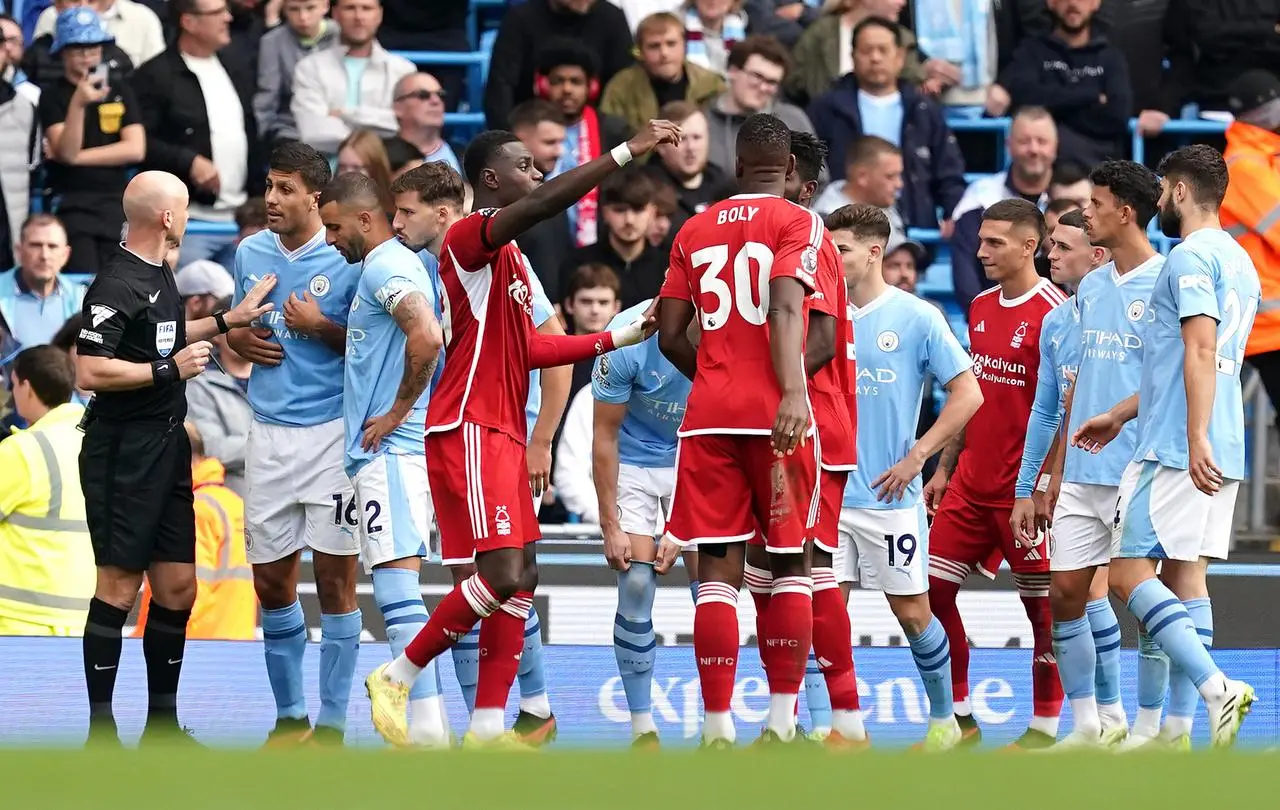 Referee Anthony Talyor, left, speaks to Rodri after sending him off against Nottingham Forest