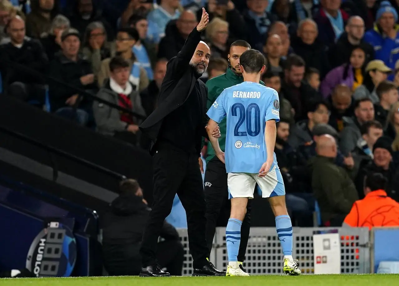 Pep Guardiola speaks to Bernardo Silva, right, as he leaves the pitch