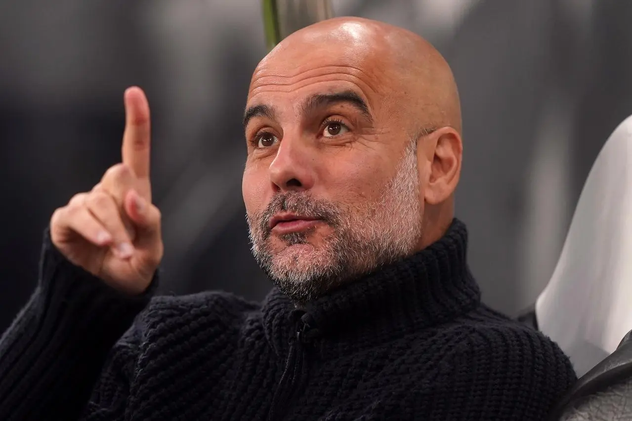 Pep Guardiola points his finger up in the air