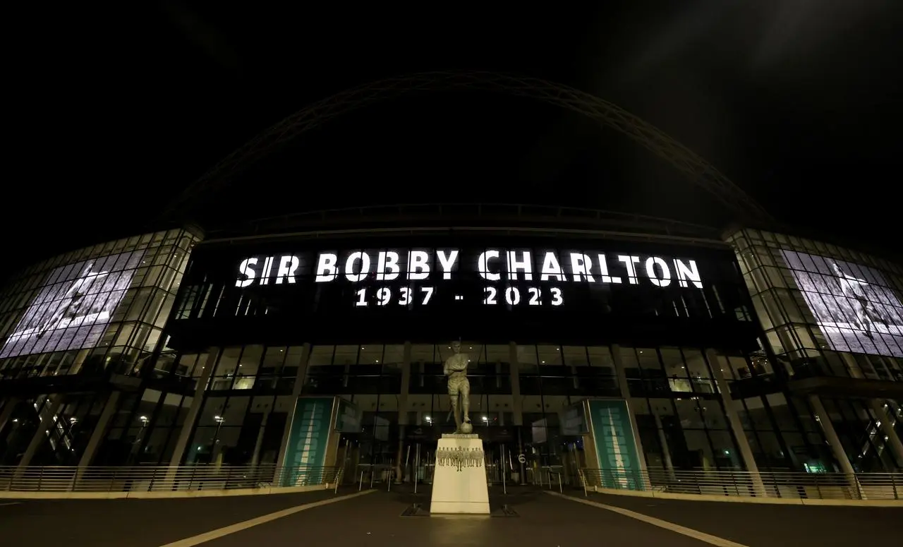 A tribute to Sir Bobby Charlton is displayed on giant screens outside Wembley Stadium