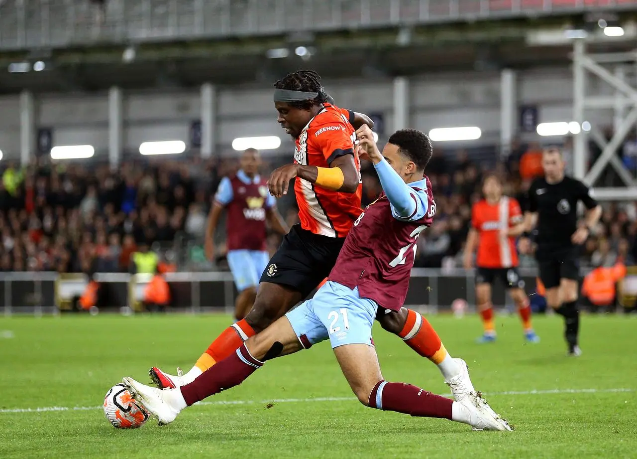 Luton Town’s Pelly Ruddock Mpanzu, left, and Burnley’s Aaron Ramsey battle for possession