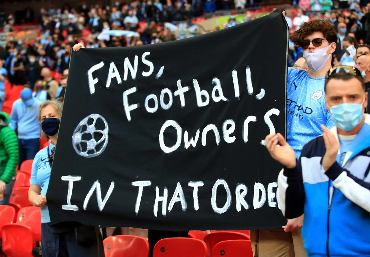 Fans hold up a banner protesting against the European Super League