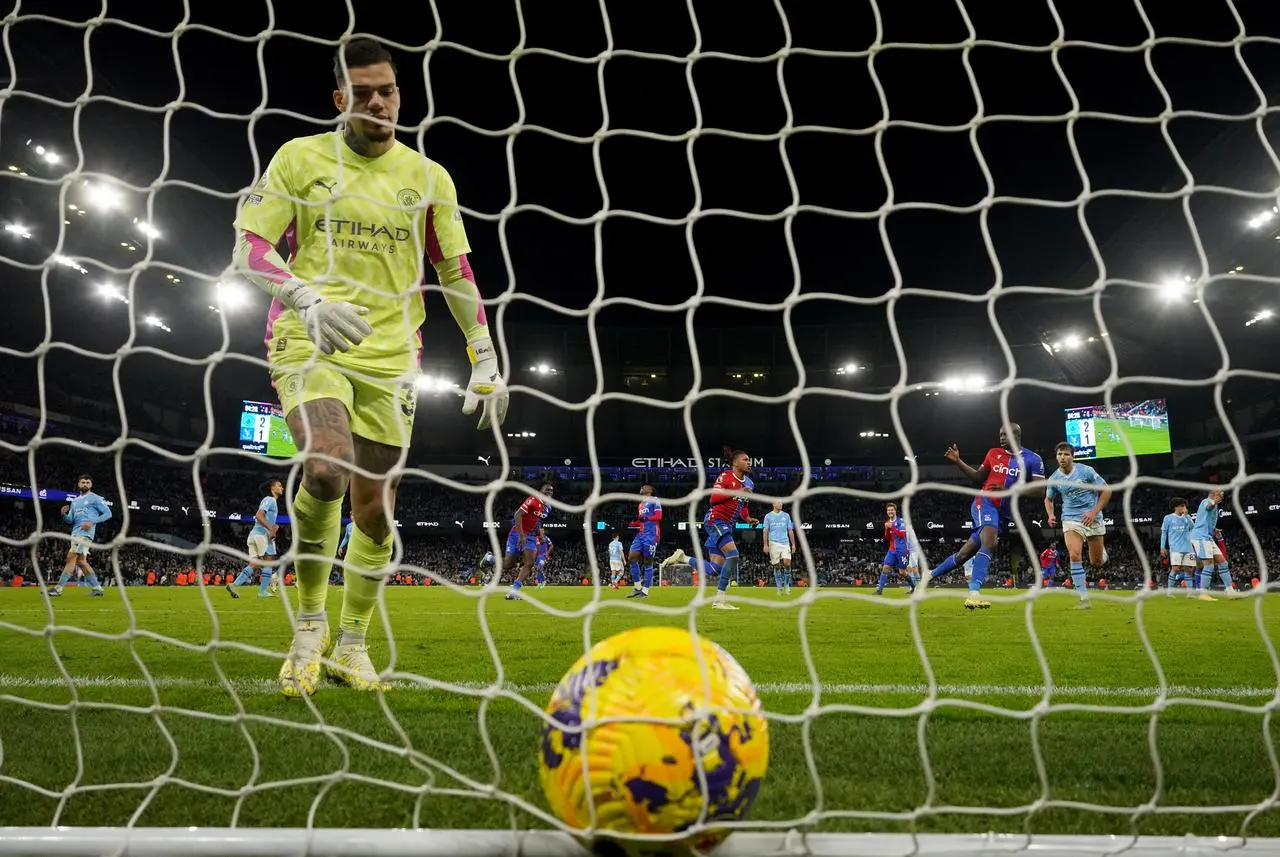 Manchester City goalkeeper Ederson picks the ball out of his net after Crystal Palace's equaliser 