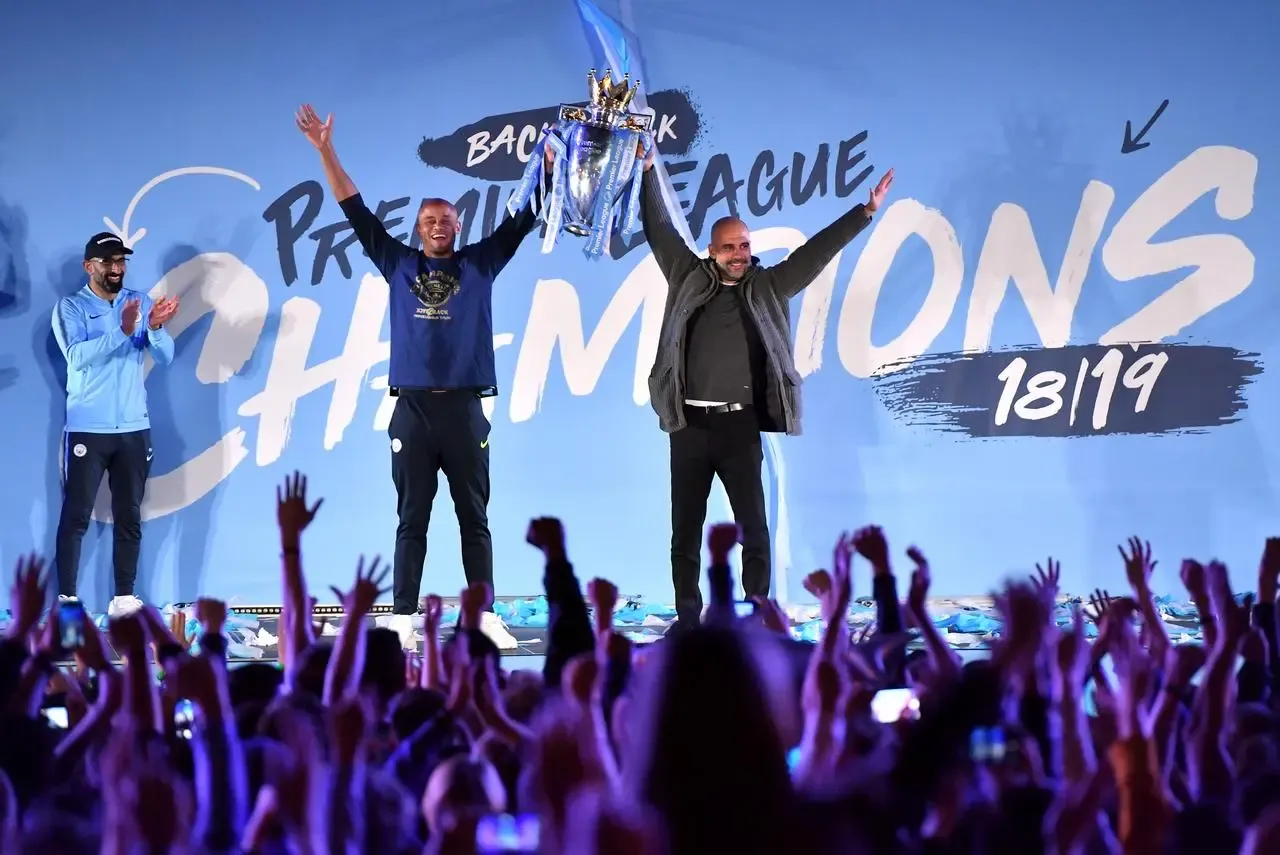 Captain Vincent Kompany and manager Pep Guardiola on stage with the trophy at Manchester City's 2018-19 title celebration