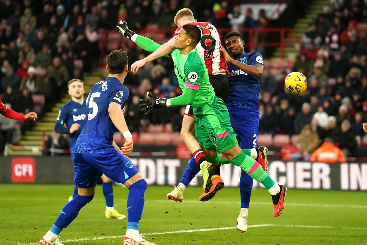 West Ham goalkeeper Alphonse Areola, centre, challenges Sheffield United’s Oli McBurnie and concedes a penalty