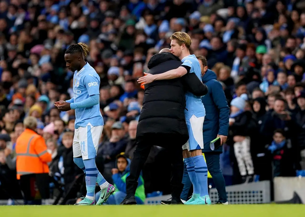 Pep Guardiola embraces Kevin De Bruyne, right, as he comes on as a substitute against Huddersfield