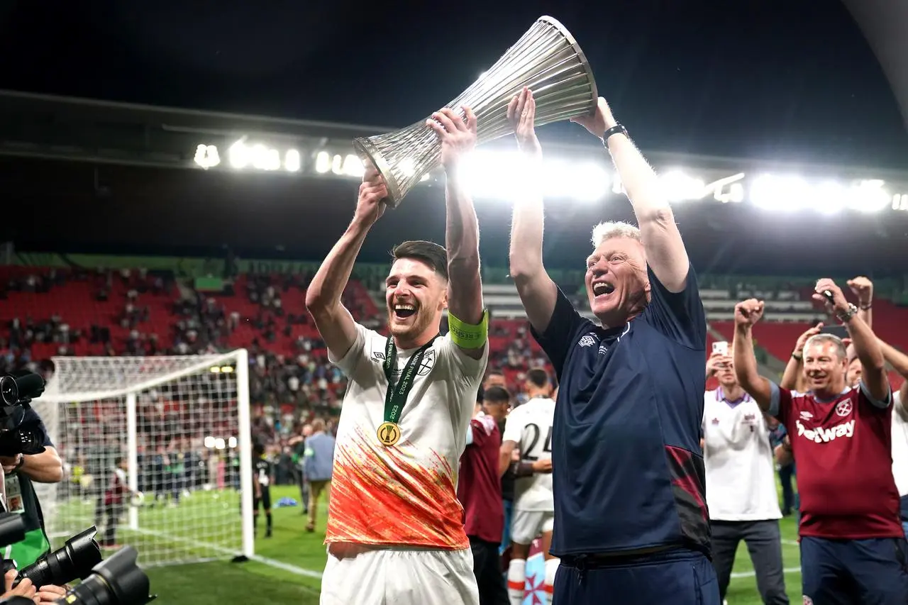 West Ham’s Declan Rice, left, and manager David Moyes lift the Europa Conference League trophy