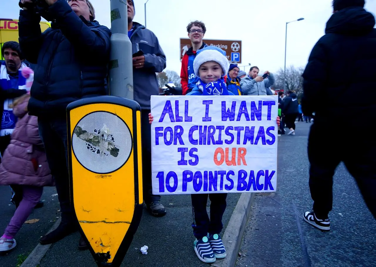 An Everton fan holds up a sign in protest of the club’s original point deduction 