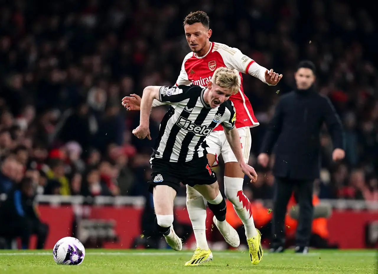 Newcastle United’s Anthony Gordon goes down under pressure from Ben White