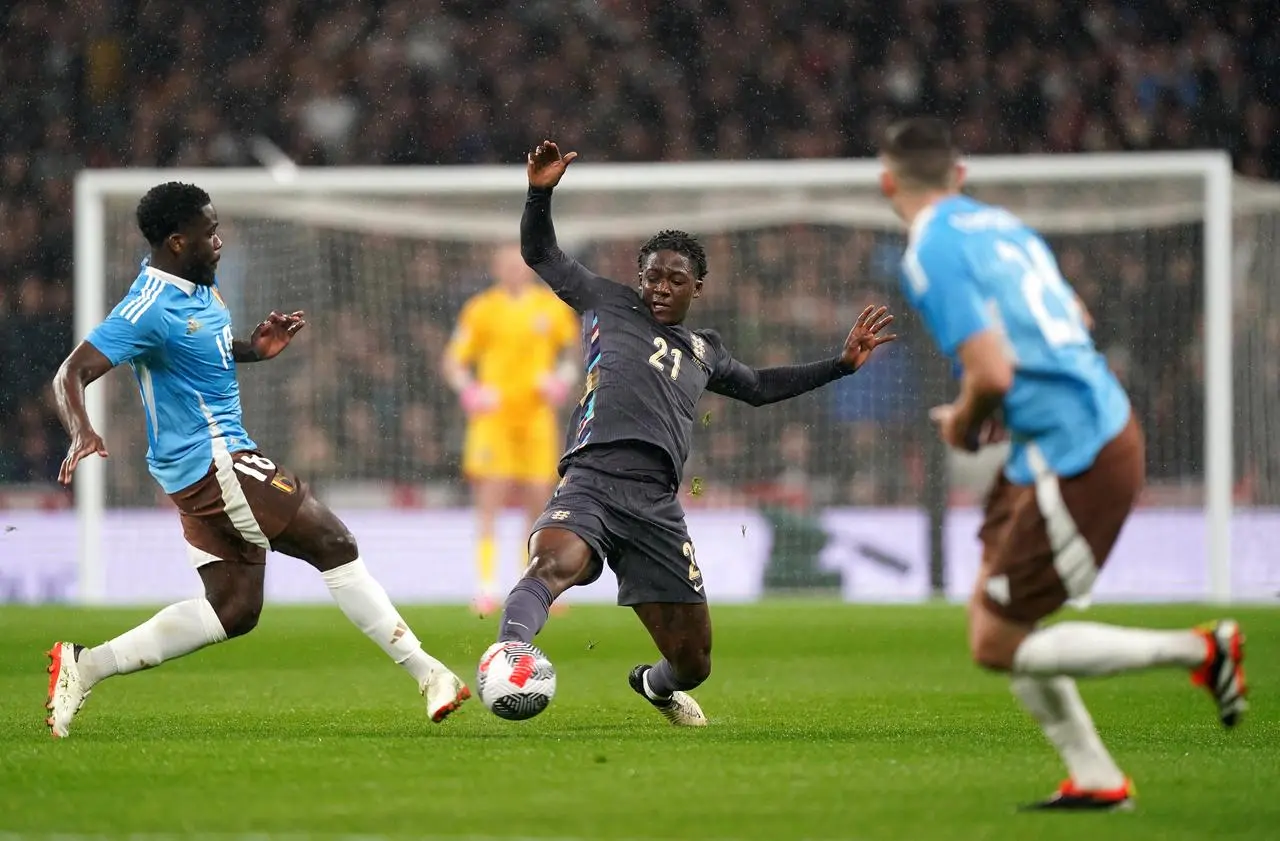 Kobbie Mainoo, centre, competes for the ball with Belgium's Orel Mangala, left