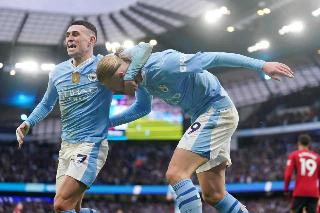 Erling Haaland, right, celebrates with Phil Foden after scoring against Manchester United in March