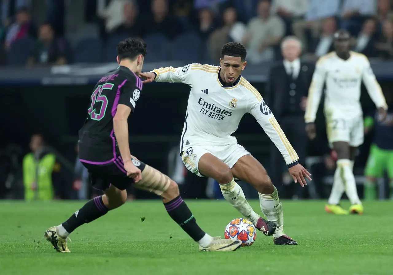 Jude Bellingham tries to dribble past Aleksandar Pavlovic during Real Madrid's Champions League match with Bayern Munich