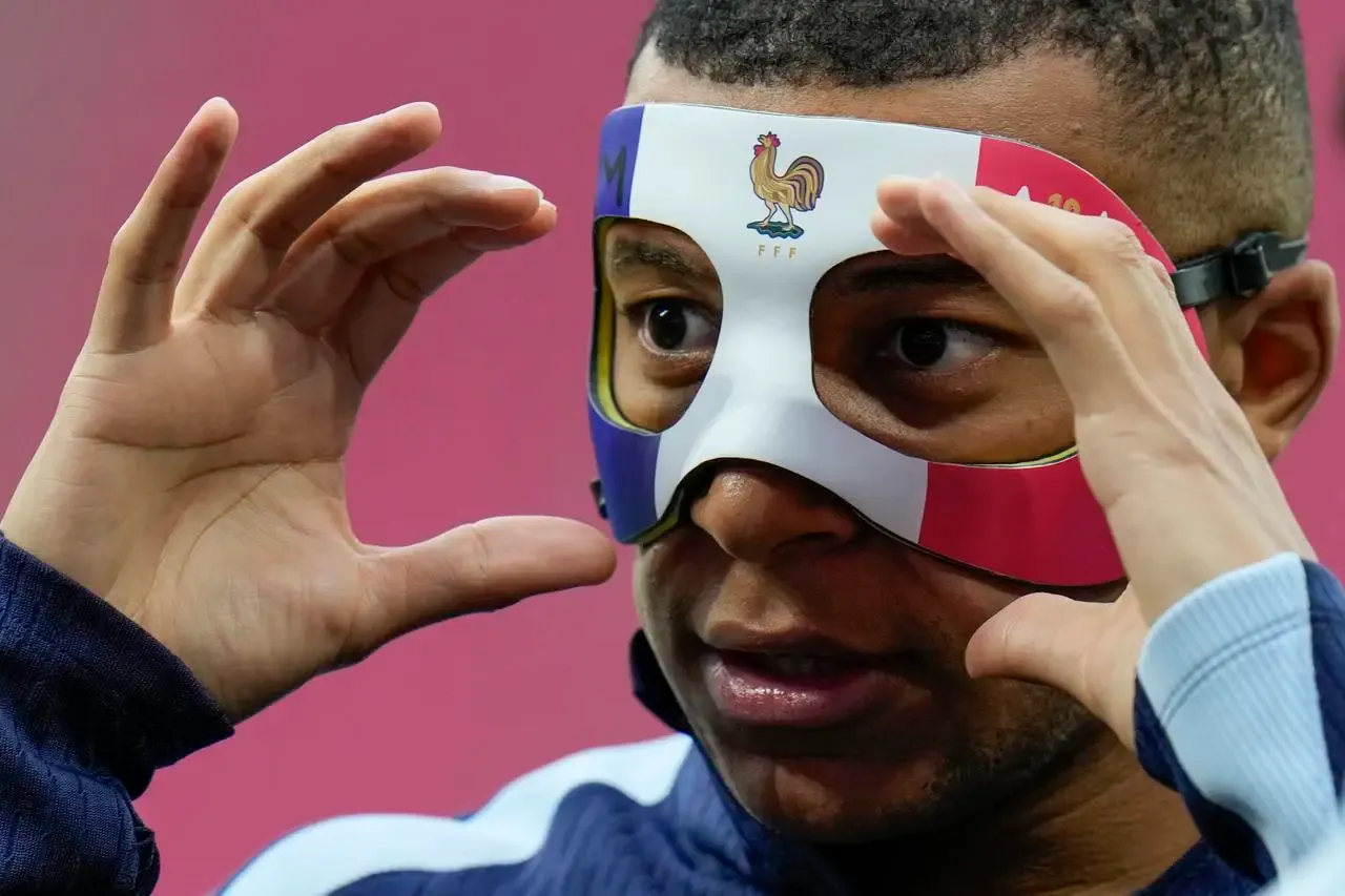 Kylian Mbappe wears a protective mask