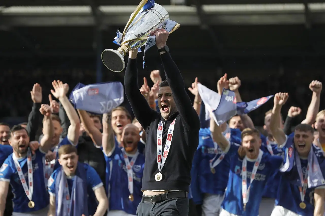 Portsmouth manager John Mousinho lifts the League One trophy