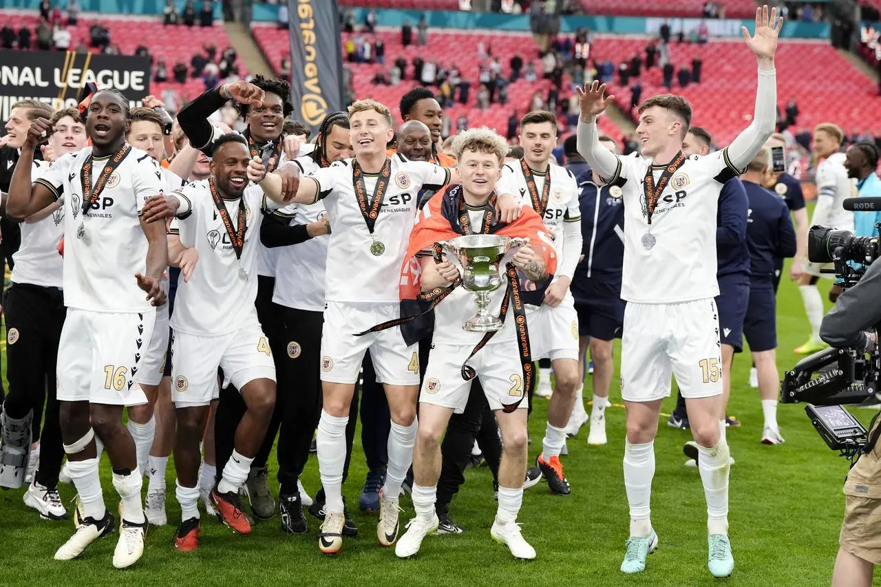 Bromley’s Jude Arthurs and team-mates celebrate with the trophy after winning the Vanarama National League play-off final