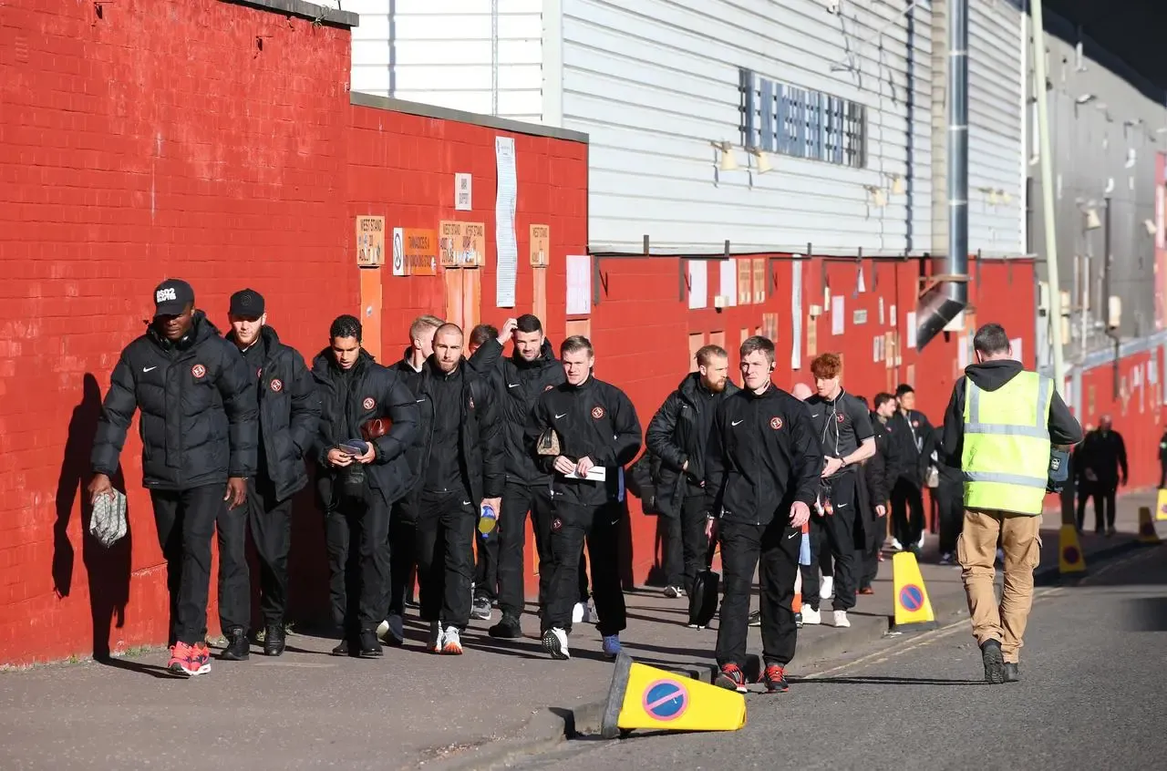 Dundee United players walk from their home stadium Tannadice Park to Dundee’s Dens Park