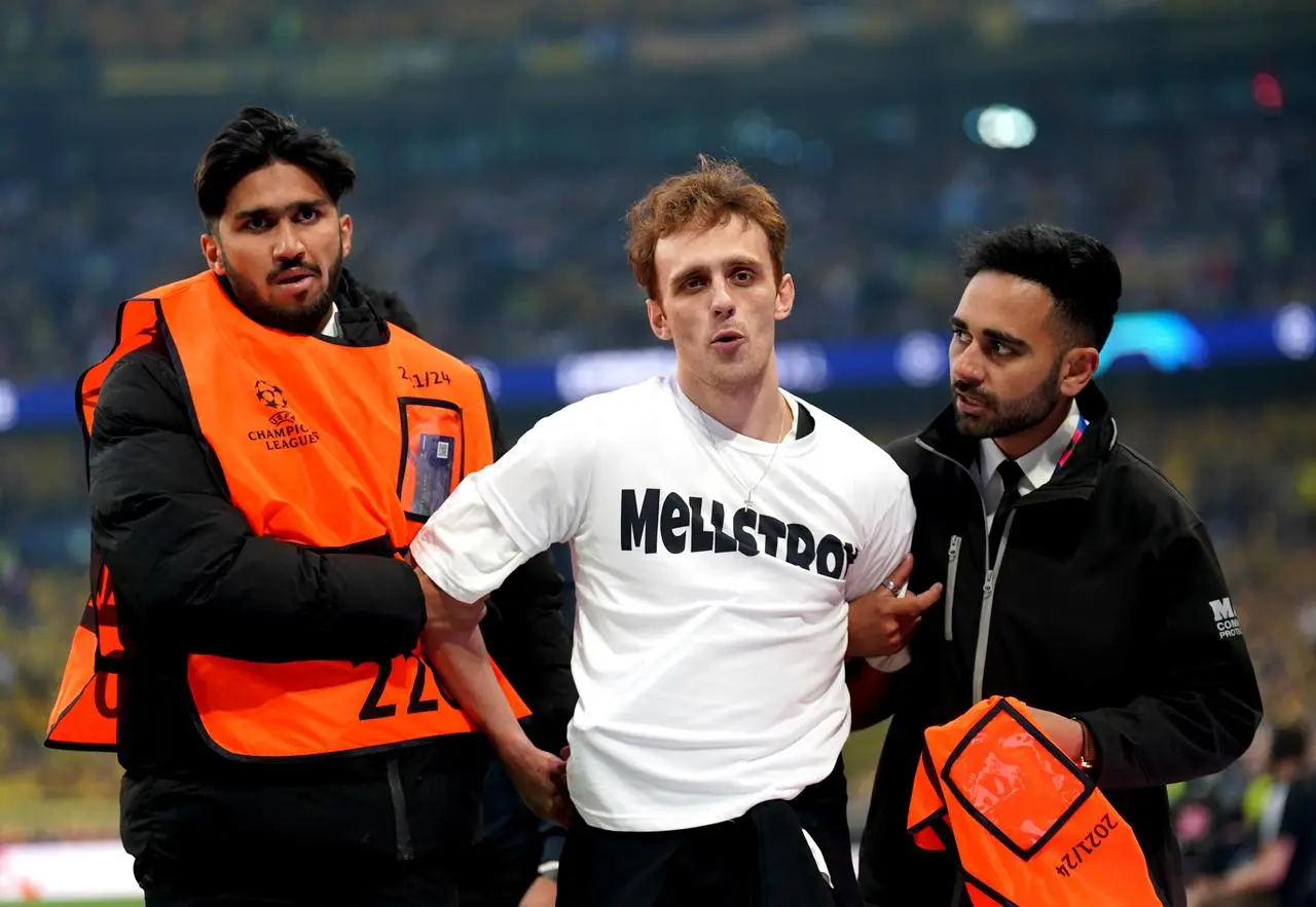 Stewards remove a pitch invader during the Champions League final at Wembley