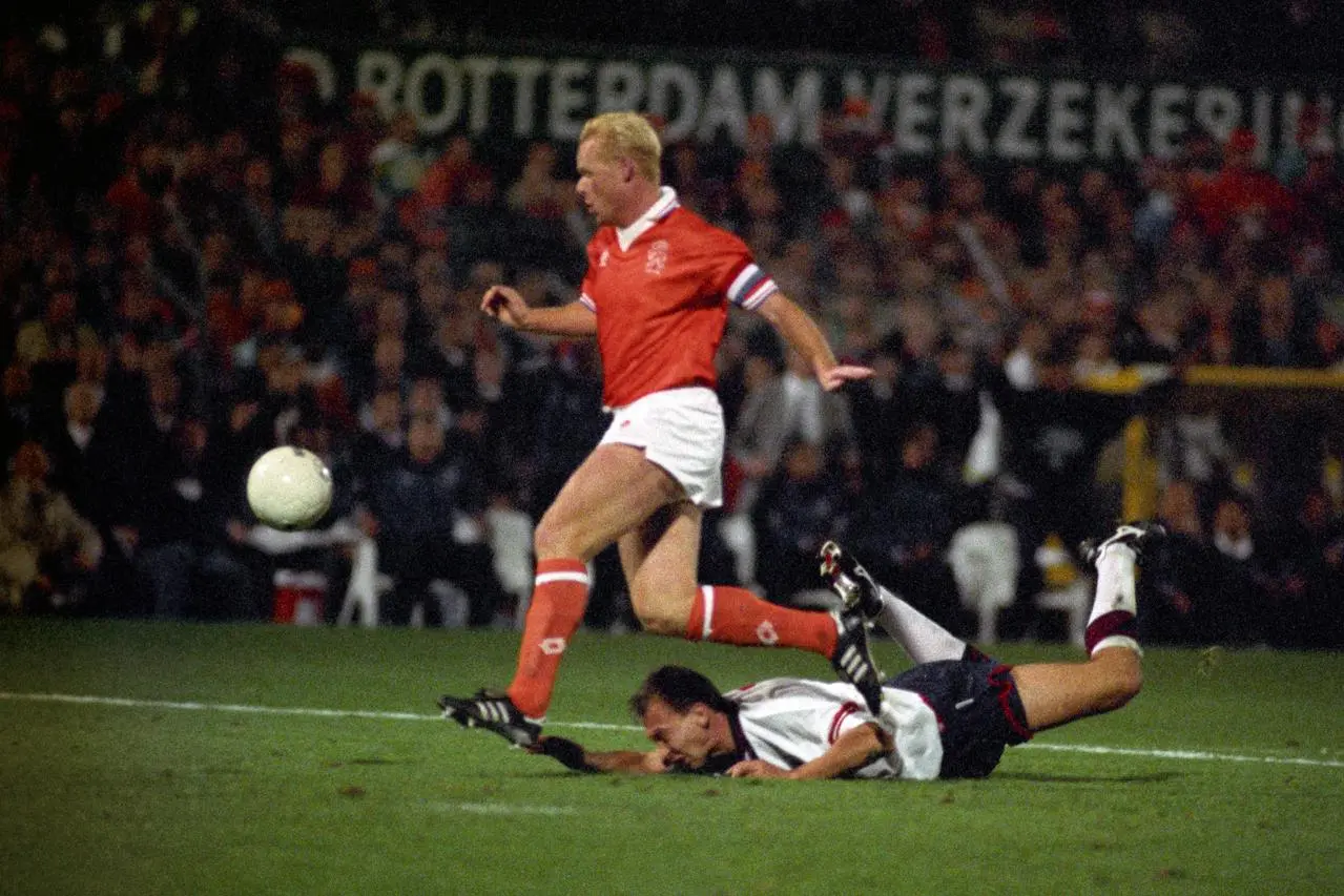 England midfielder David Platt lies face down on the ground as Netherlands defender Ronald Koeman clears the ball