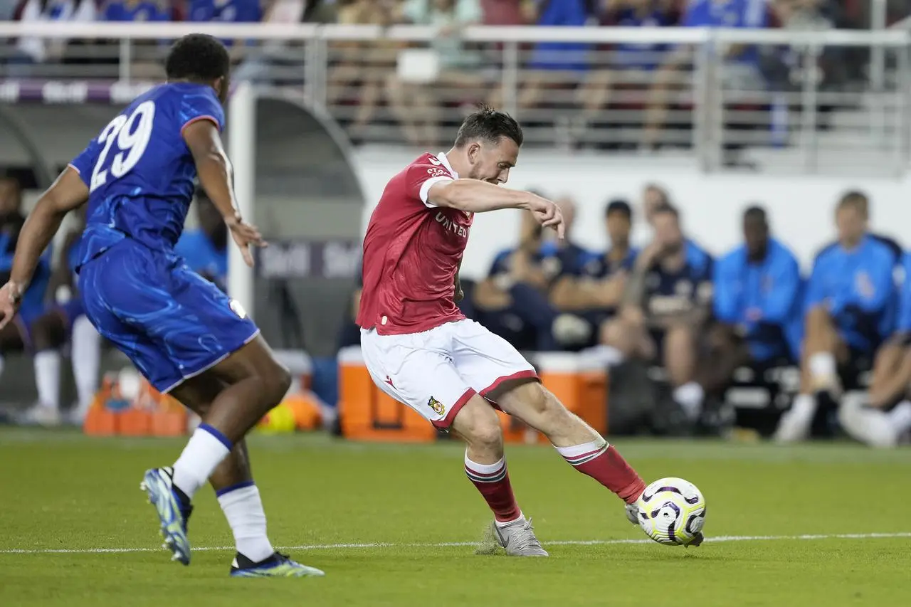 Wrexham forward Jack Marriott shoots left-footed Chelsea defender Wesley Fofana