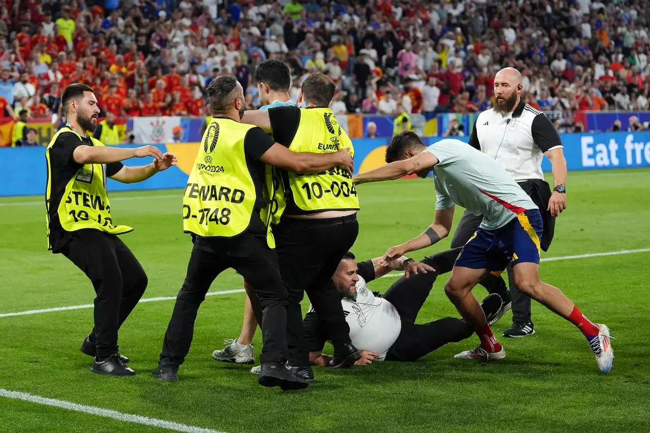 Spain’s Alvaro Morata (second right) is injured in a collision with a security guard who slipped