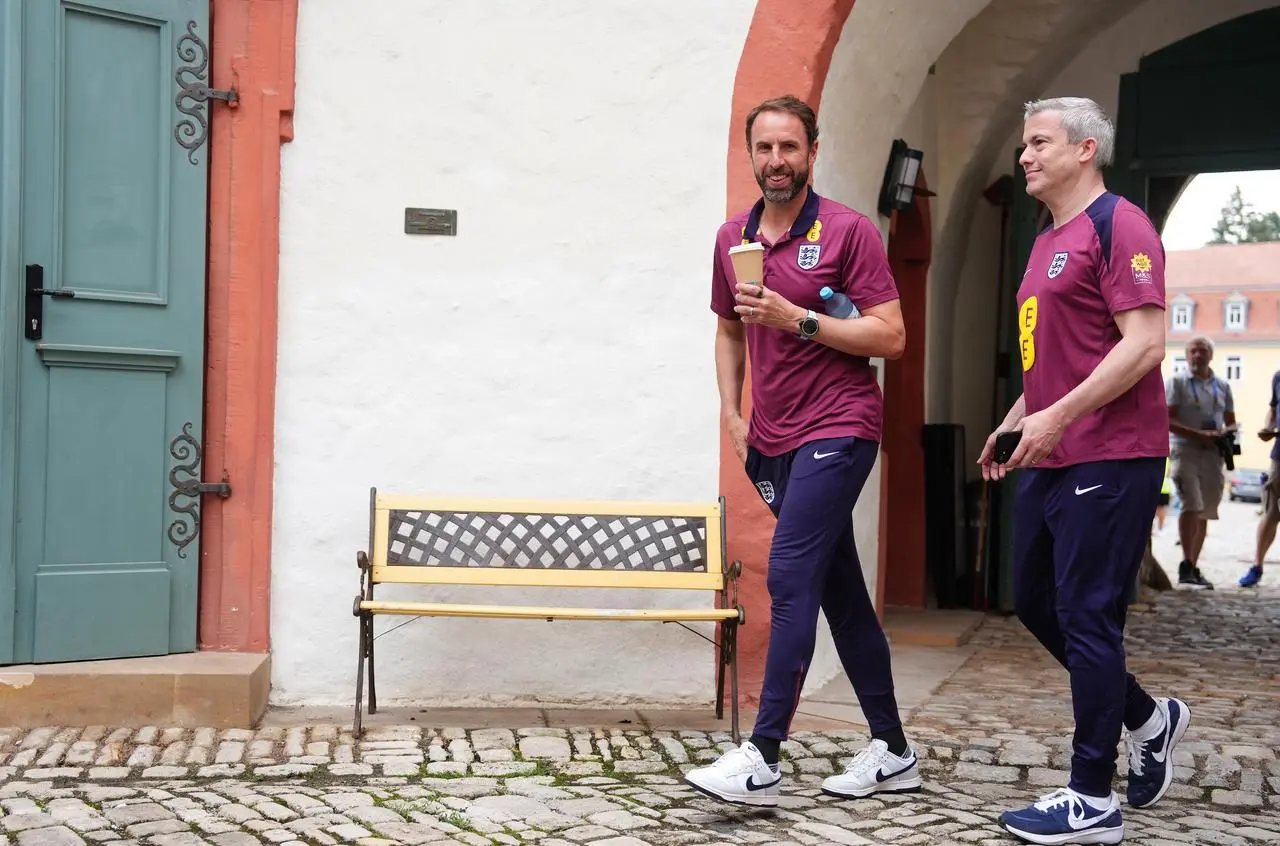 England manager Gareth Southgate walking holding a cup 