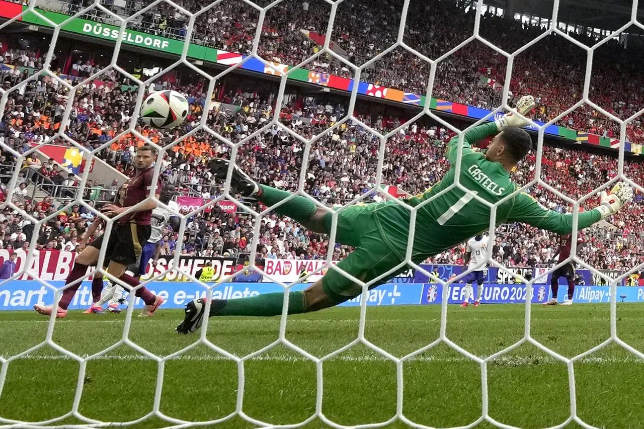 Belgium’s Jan Vertonghen, left, scores an own goal in the game against France