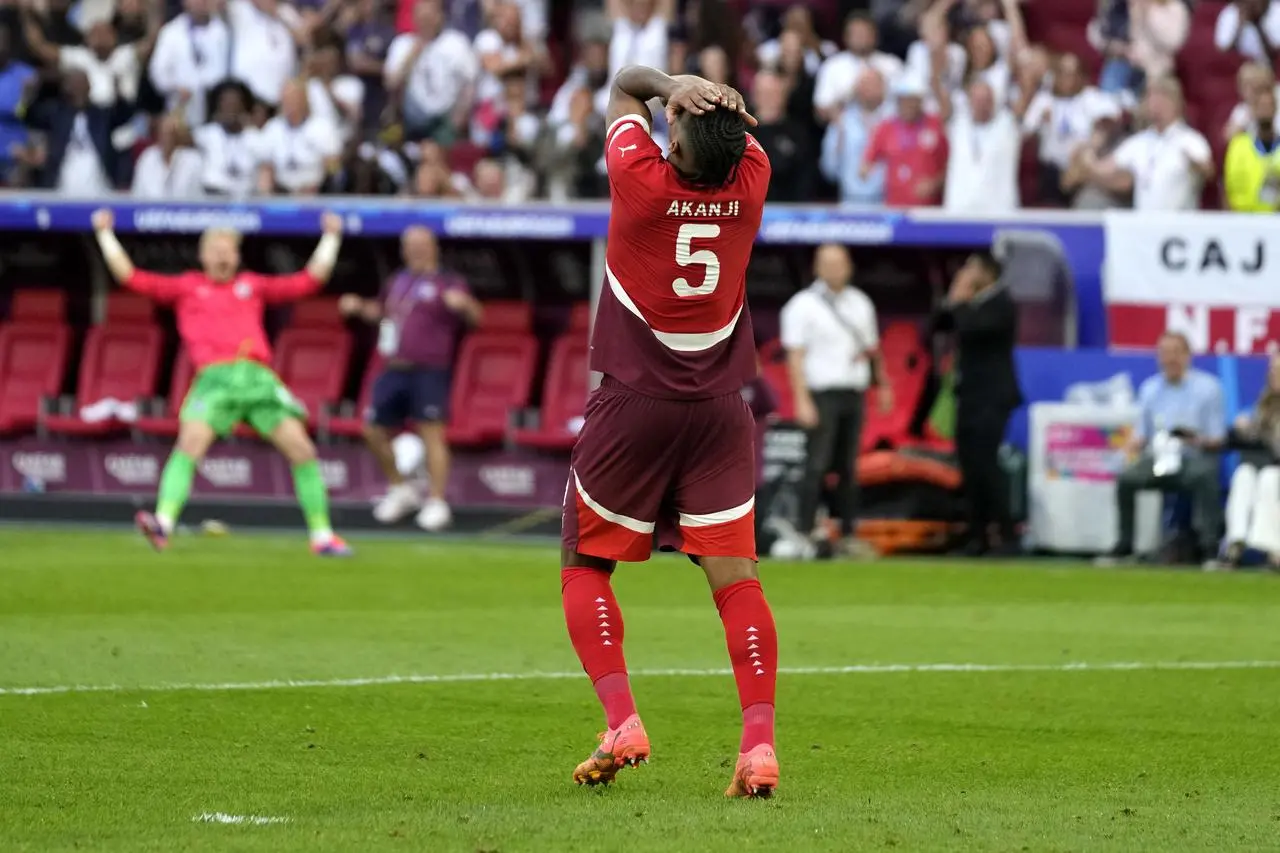 Switzerland’s Manuel Akanji reacts after missing his penalty