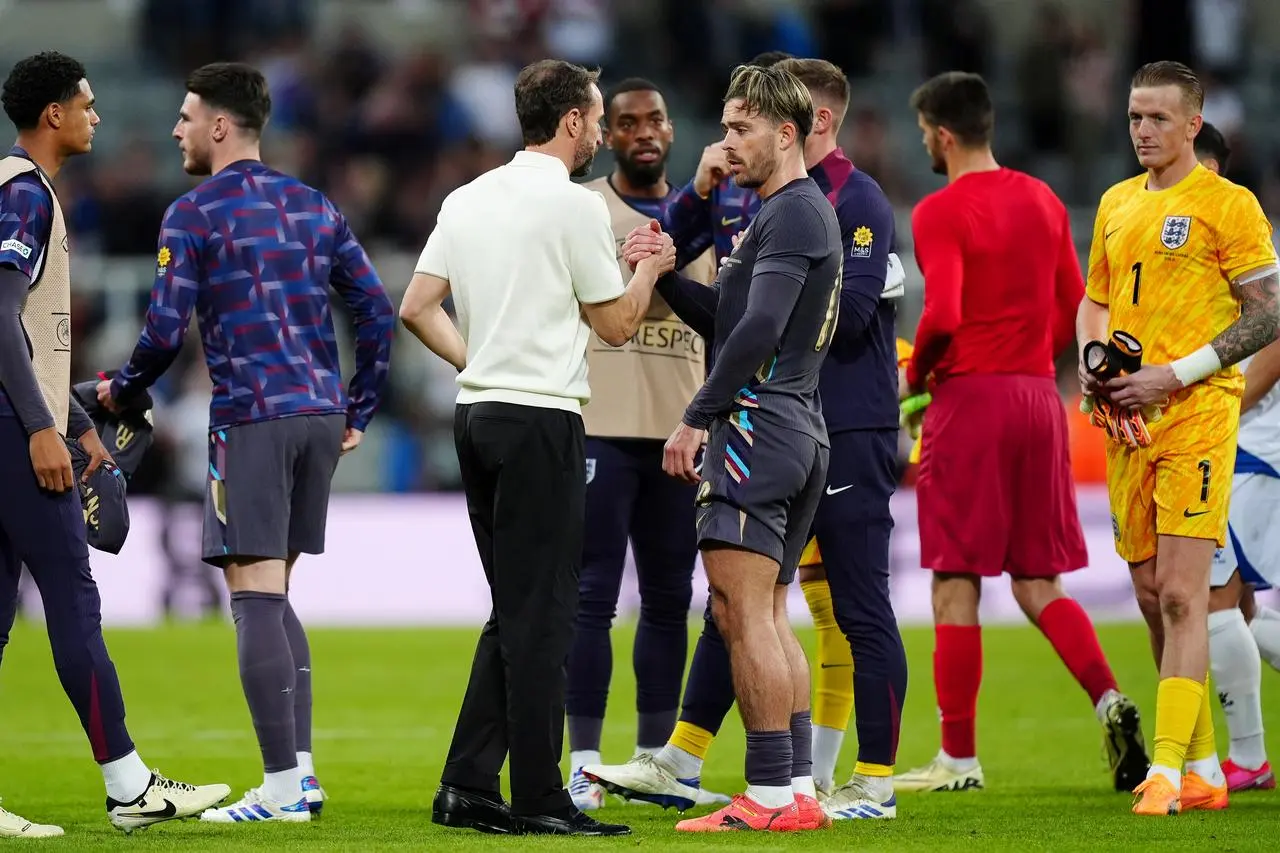 England manager Gareth Southgate kneels down next to Jack Grealish 