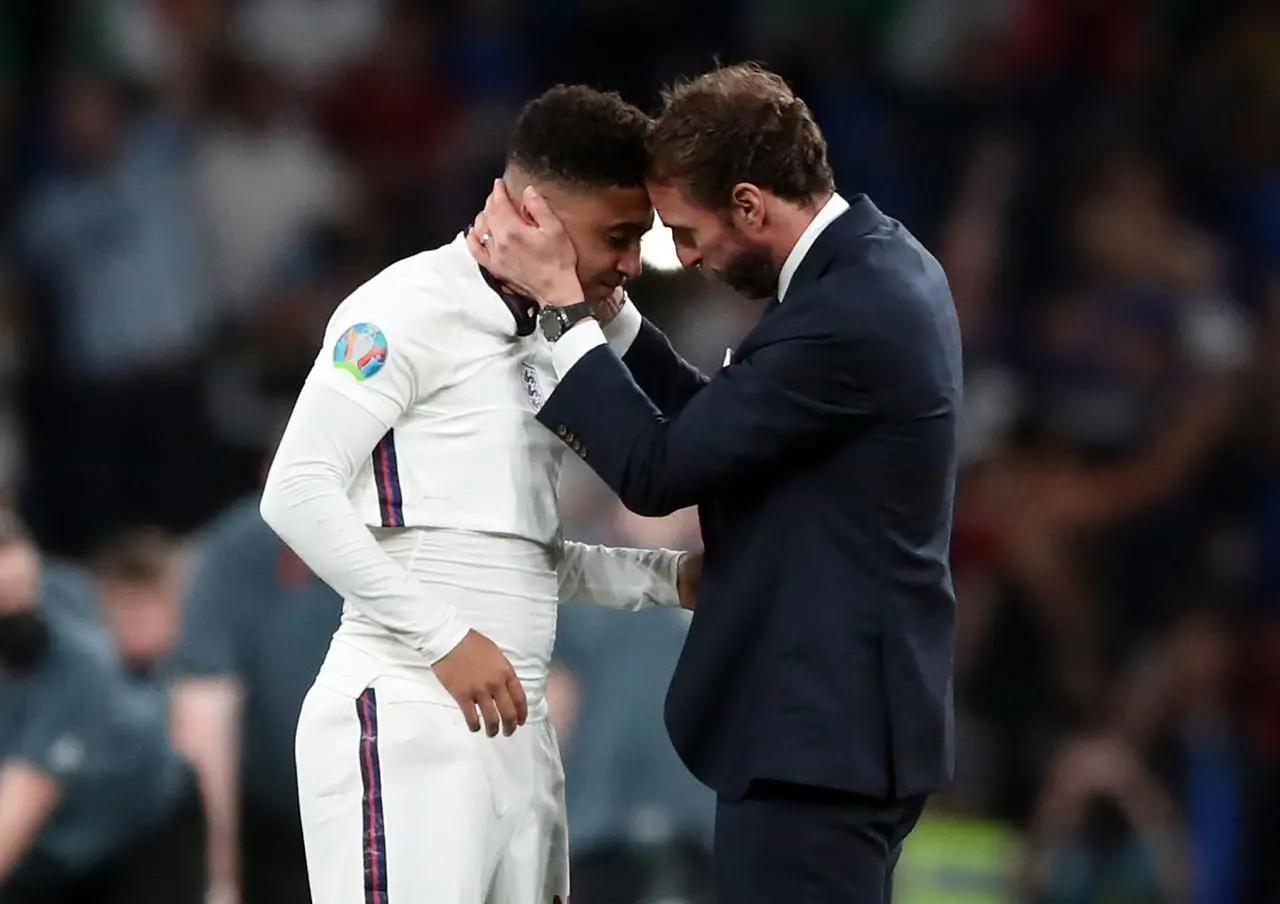 England manager Gareth Southgate puts both hands around Jadon Sancho's face as he consoles the winger after his penalty miss against Italy in the Euro 2020 final