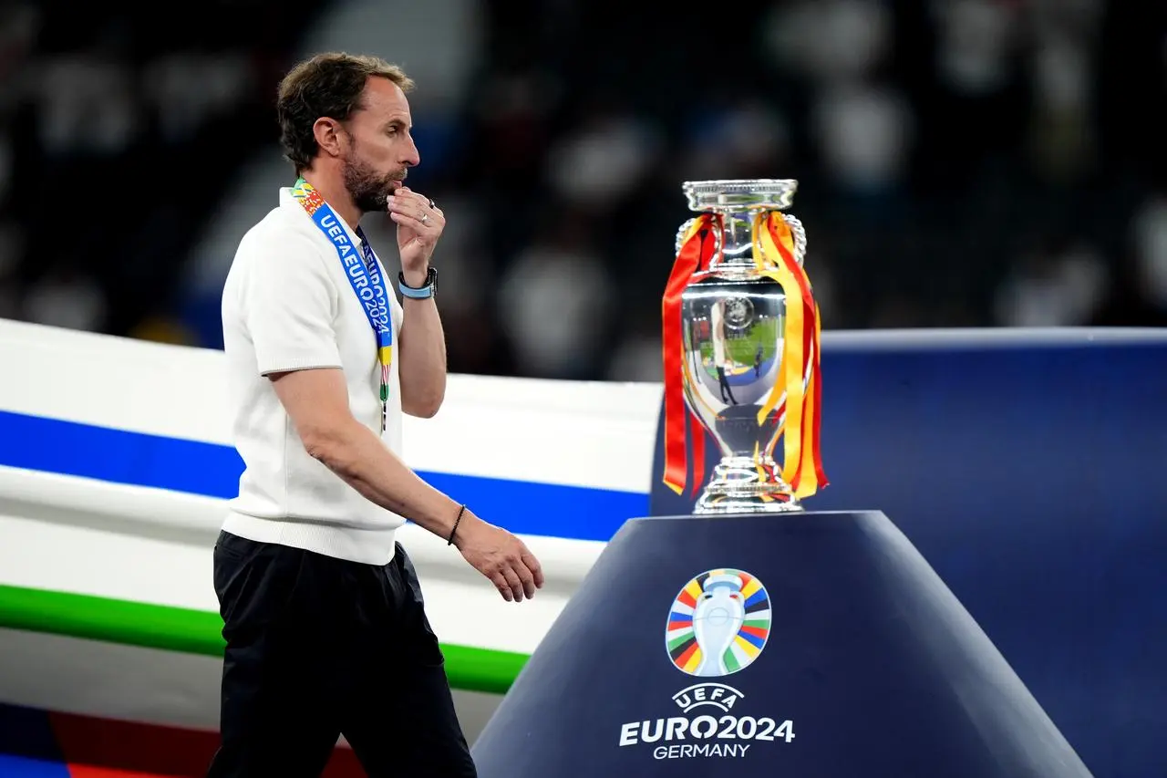 Former England manager Gareth Southgate walks dejected past the Euro 2024 trophy