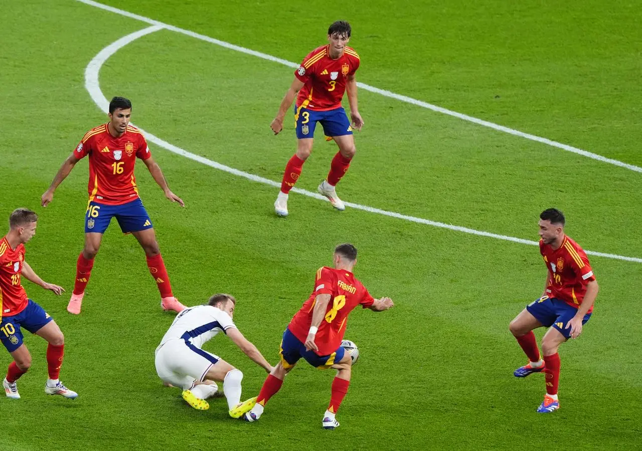 England’s Harry Kane, centre, fouls Spain’s Fabian Ruiz, second right, leading to a yellow card