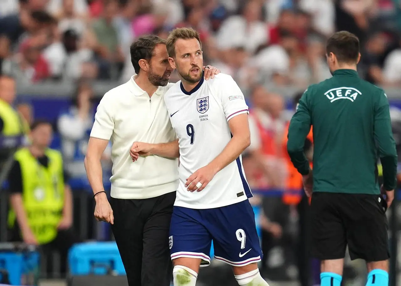 England manager Gareth Southgate, left, puts his arm round Harry Kane as he is substituted against Denmark