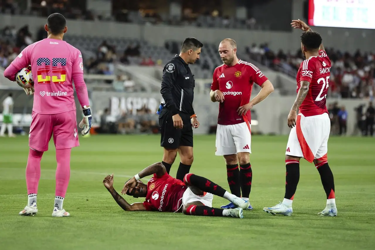 Manchester United’s Marcus Rashford lies on the ground as Jadon Sancho calls for the physio with Christian Eriksen, Real Betis goalkeeper Francisco Vieites and the referee watching on