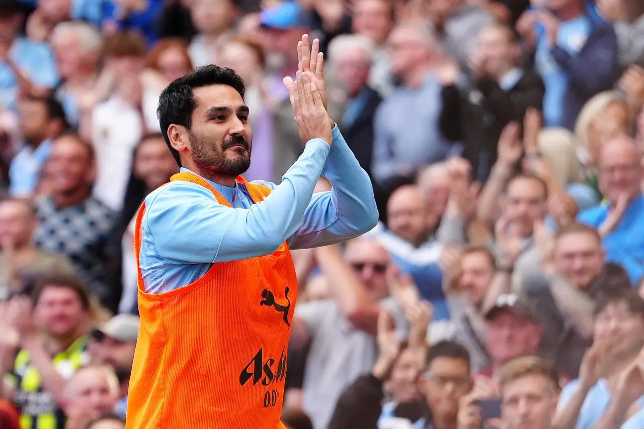 Ilkay Gundogan applauds fans as he warms up ahead of his second debut