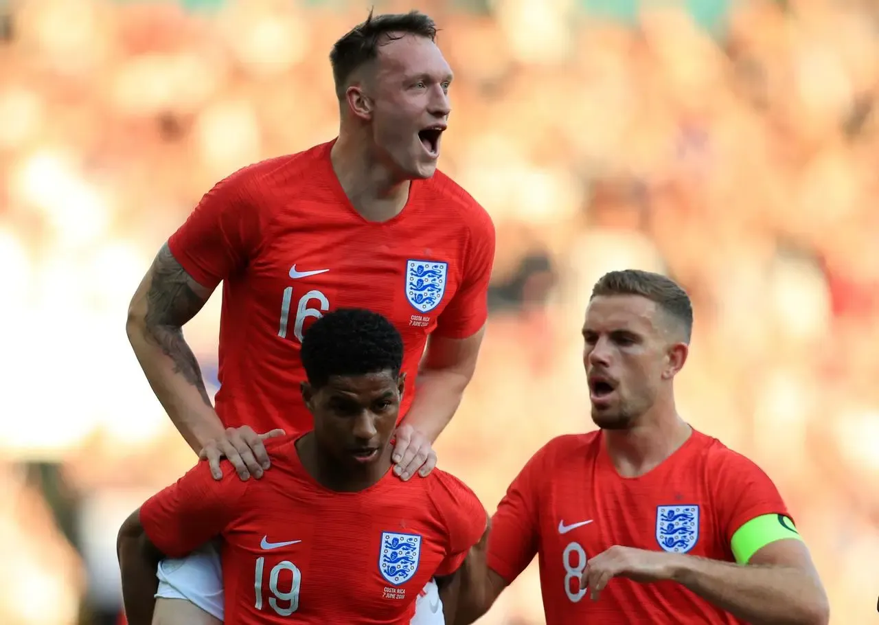 Phil Jones, top, celebrates with Marcus Rashford and Jordan Henderson