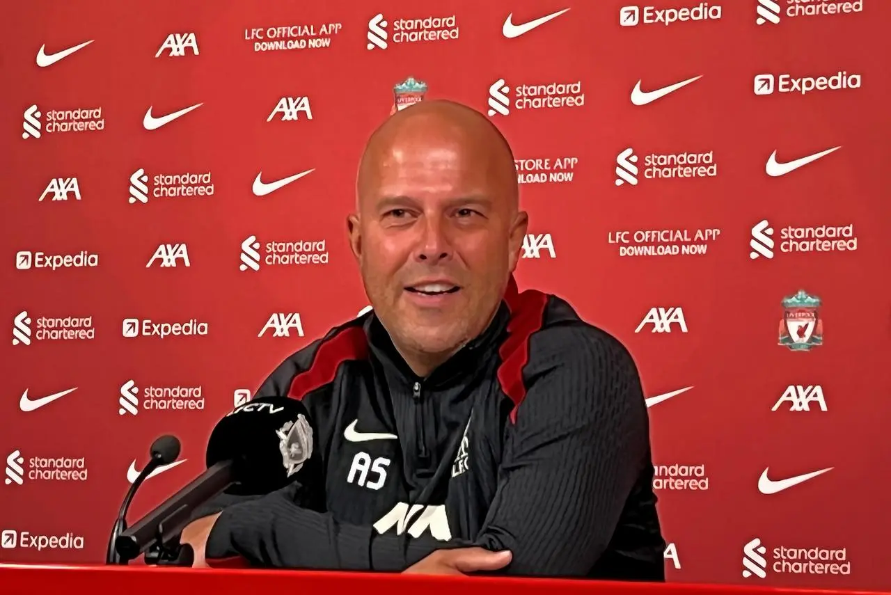 Arne Slot in front of a red sponsored backdrop at his first press conference as Liverpool manager