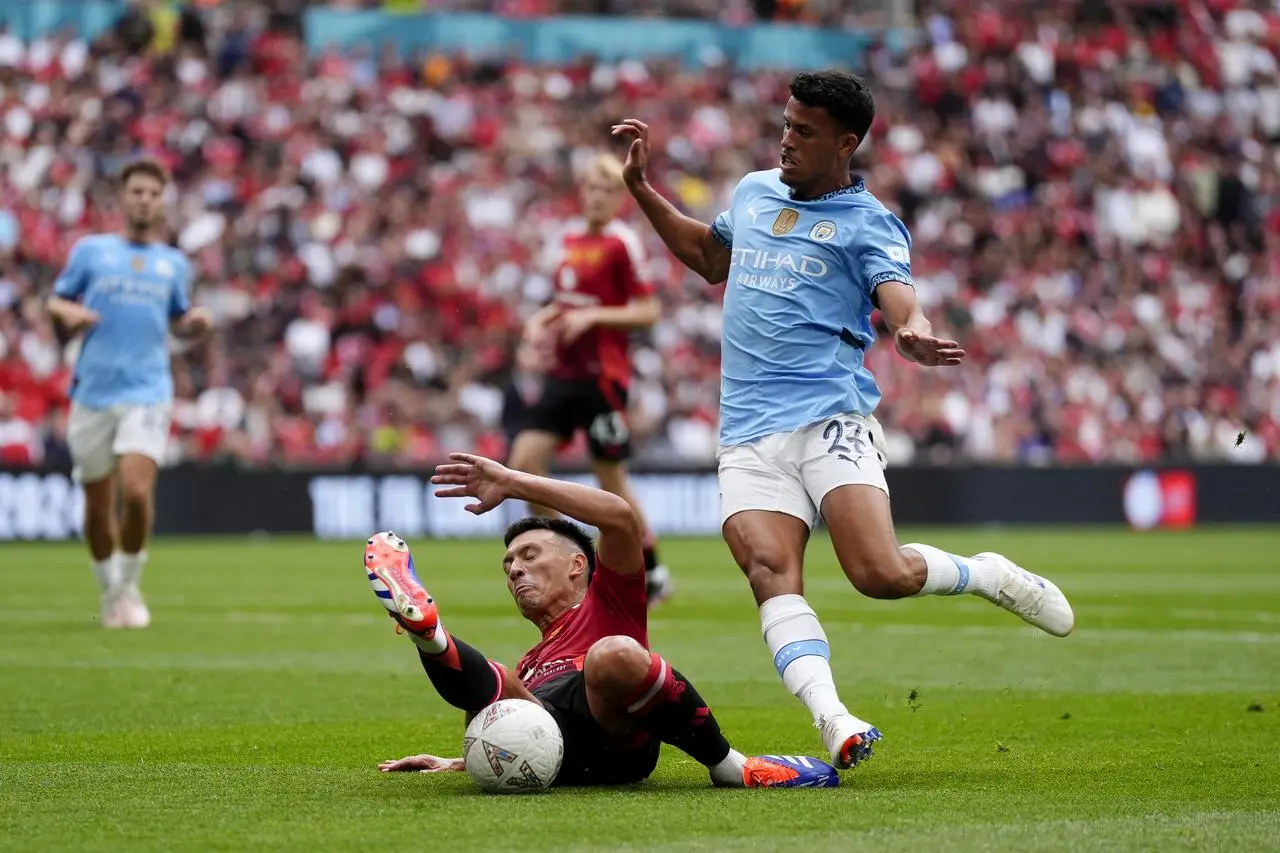 Manchester City midfielder Matheus Nunes, right, is tackled during the FA Community Shield at Wembley