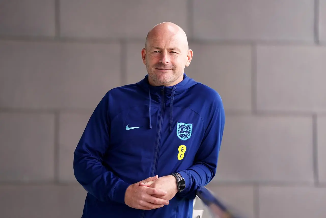 Lee Carsley leans against a railing as he poses for a photo wearing England tracksuit last September