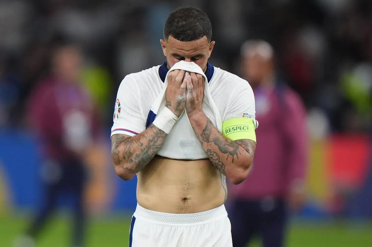 England's Kyle Walker pulls his shirt over his lower face in disappointment