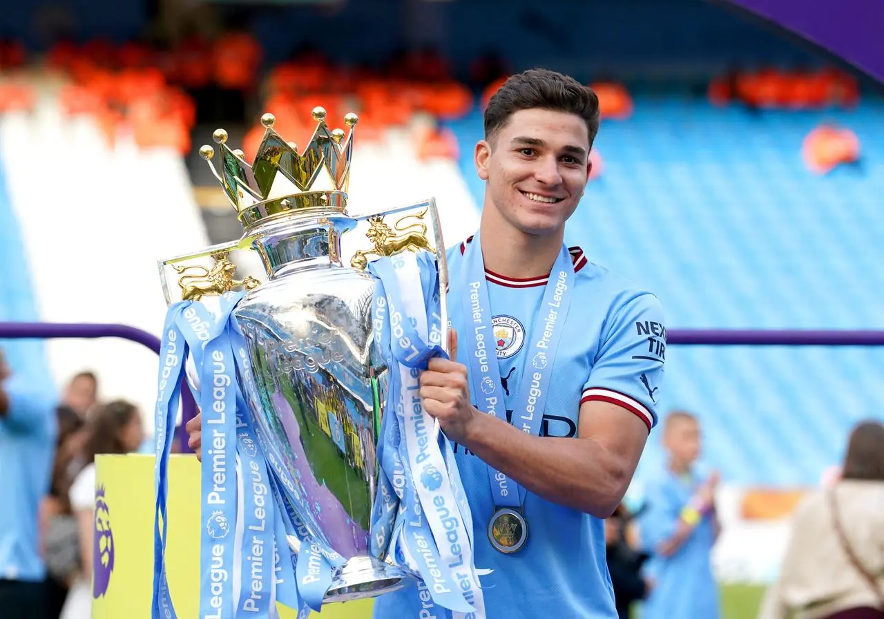 Julian Alvarez celebrates with the Premier League trophy in May 2023 following Manchester City's title success