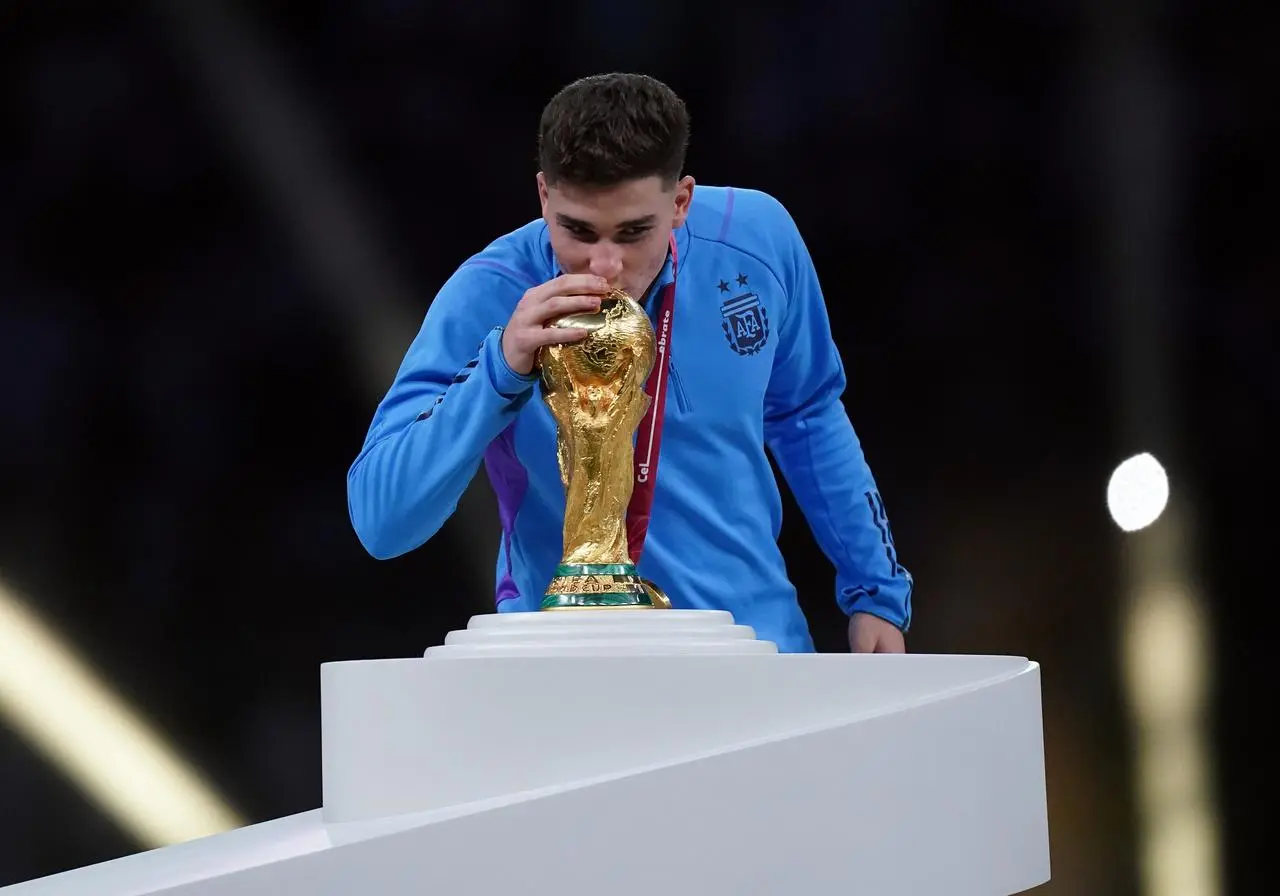 Argentina forward Julian Alvarez kisses the World Cup trophy