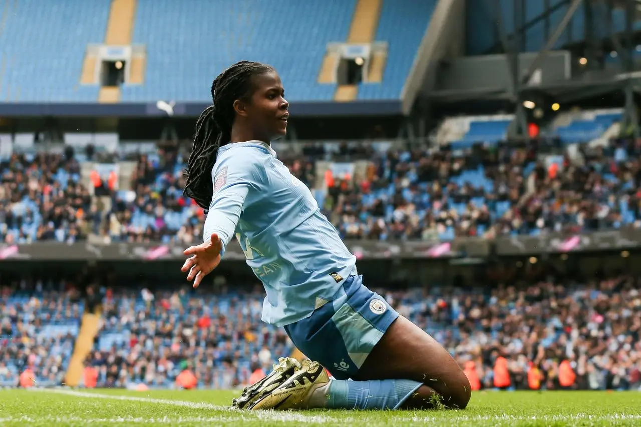 Khadija Shaw performs a knee slide after scoring for Manchester City