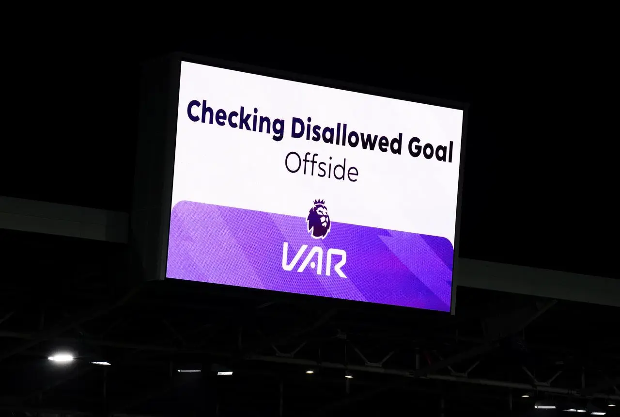 A stadium big screen shows a goal is being checked for offside
